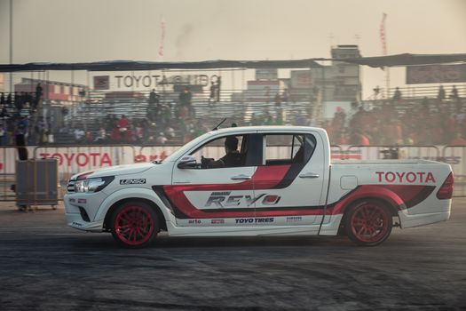 Udon Thani, Thailand - October 18, 2015: Masato Kawabata the driver of Toyota Hilux Revo waving hand to the audiences after drifting contest on the track between driver from Thailand and Japan at the event Toyota Motor Sport show at Udon Thani, Thailand  with motion blur in the background