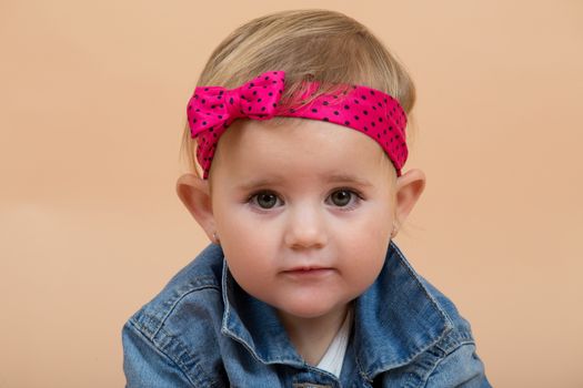 portrait of young cute baby on beige background