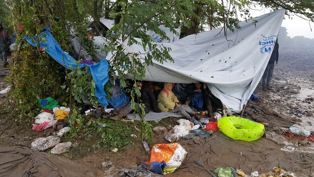 SERBIA, Sid: Refugees gather at a camp in Sid, Serbia on October 19, 2015, where they have been stranded in the cold for nearly two days before the opening of the border with Croatia that day. The area has become increasingly congested with refugees since the weekend, when Hungary closed its borders with Croatia.