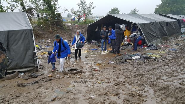 SERBIA, Sid: Refugees gather at a camp in Sid, Serbia on October 19, 2015, where they have been stranded in the cold for nearly two days before the opening of the border with Croatia that day. The area has become increasingly congested with refugees since the weekend, when Hungary closed its borders with Croatia.