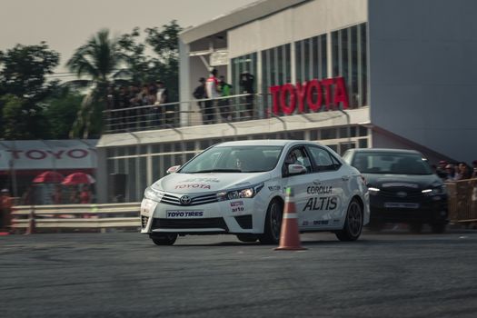 Udon Thani, Thailand - October 18, 2015: Toyota Colora Altis perform drifting on the track at the event Toyota Motor Sport show at Udon Thani, Thailand with motion blur in the background. The cars are drive by drivers from Toyota teams Thailand