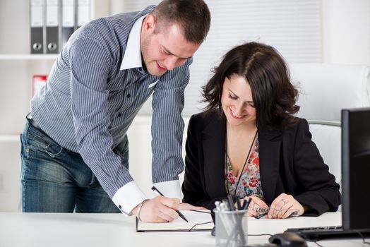 Happy businessman signing a document in the office.