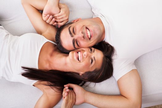 Romantic young couple Lying Down in bed. View from above.