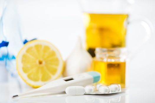 Vitamins and pills for treatment Cold And Flu. Lemon, tea, honey, garlic and Thermometer on white background.