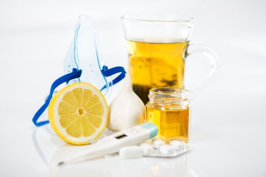 Vitamins and pills for treatment Cold And Flu. Lemon, tea, honey, garlic and Thermometer on white background.