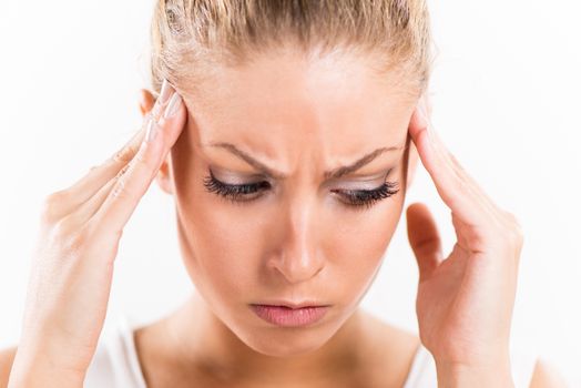 Portrait of a beautiful young woman with hands on head relieve a headache.