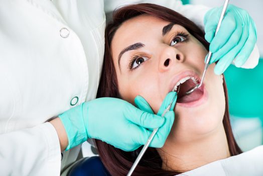 Dentist checking dental hygiene on patient mouth. Close Up.