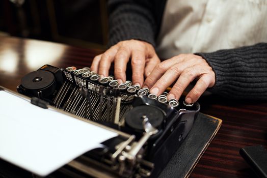 Senior man hands typing on Obsolete Typewriter.