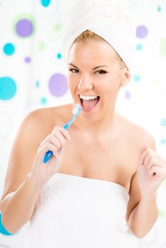 Young cute woman brushing her teeth in the bathroom and singing.