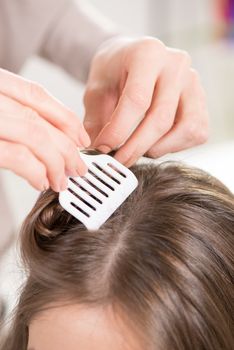 Hairdresser putting hair Clips on a woman hair. Close-up.