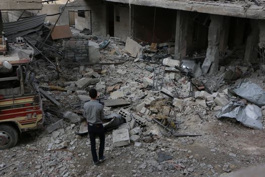 SYRIA, Damascus: A Syrian man looks at damaged buildings in the Marj al-Sultan neighborhood in eastern Damascus on October 24, 2015.