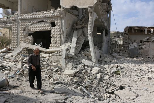 SYRIA, Damascus: A Syrian man walks amid damaged buildings in the Marj al-Sultan neighborhood in eastern Damascus on October 24, 2015.