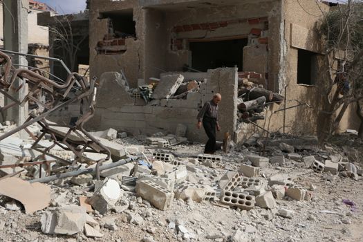 SYRIA, Damascus: A Syrian man walks amid damaged buildings in the Marj al-Sultan neighborhood in eastern Damascus on October 24, 2015.