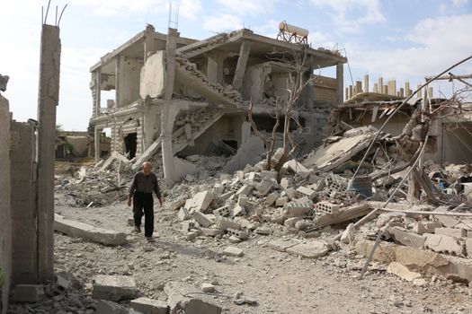 SYRIA, Damascus: A Syrian man walks amid damaged buildings in the Marj al-Sultan neighborhood in eastern Damascus on October 24, 2015.