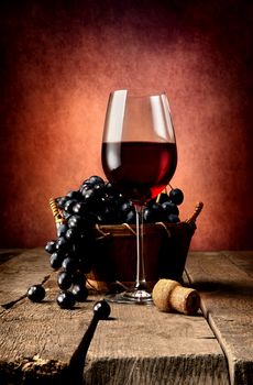 Basket of grape and wine on wooden table