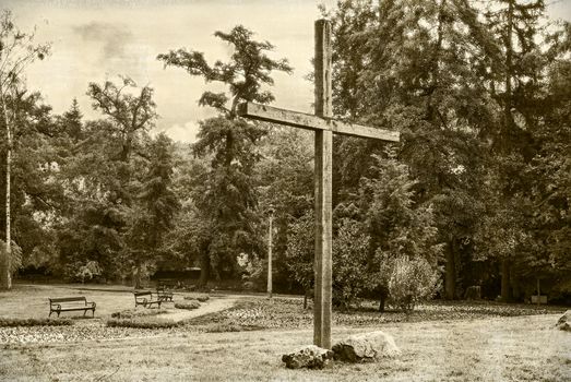 Retro photograph wooden cross  against a dramatic forest