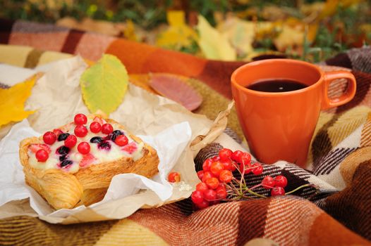 Romantic autumn still life with plaid, cake, coffee cup and leaves