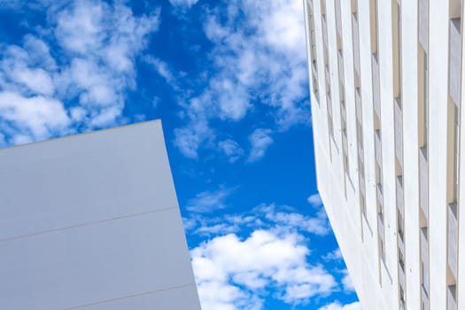 skyscrapers under blue sky with white clouds, business building concept