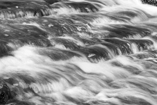 Beautiful background with the water of a fast creek 