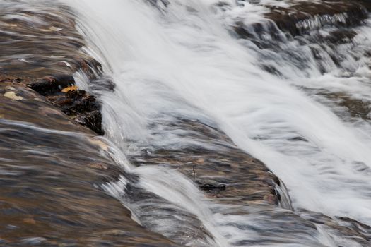 Beautiful small waterfalls of a fast creek in the forest