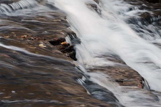 The fast water movement in a creek with waterfalls