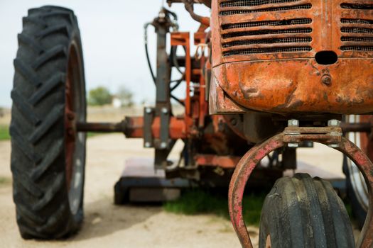 Showing the front radiator and part of the tire of an old time rusted out tractor