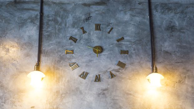 Cement wall with vintage clock and light bulbs