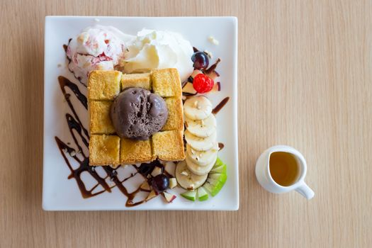 Honey toast and whipping cream with chocolate ice cream on wood background