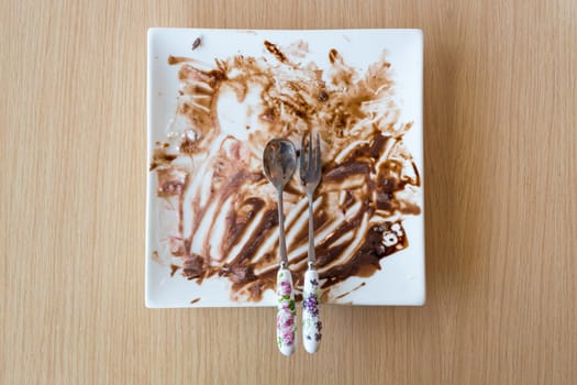 Leftovers of food on the white modern plate on wood background