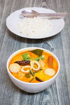 Tom Yum Kung-Thai spicy soup with Thai Jasmine Rice on wood background