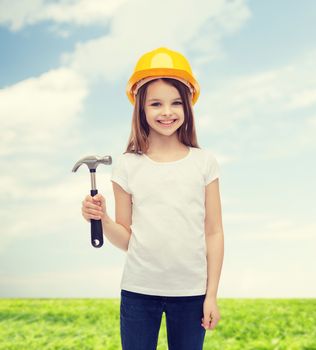 construction and people concept - smiling little girl in protective helmet with hammer