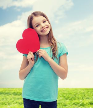 love, happiness and people concept - smiling little girl with red heart