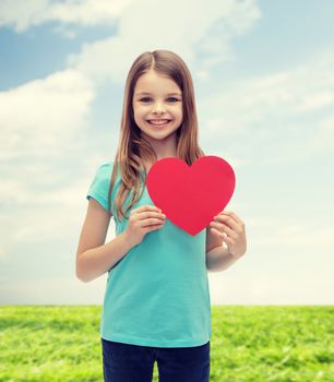 love, happiness and people concept - smiling little girl with red heart