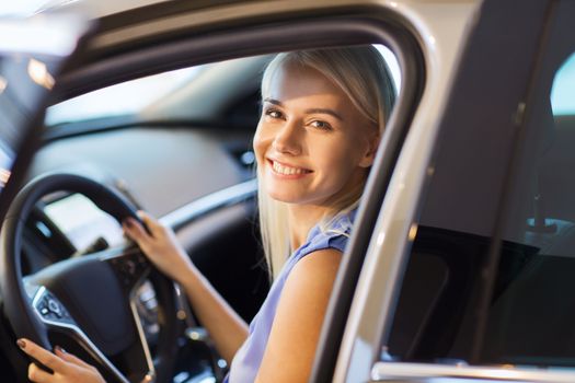 auto business, car sale, consumerism , transportation and people concept - happy woman sitting in or driving car