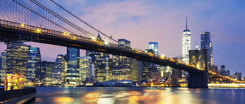 Panoramic view of New York City Manhattan midtown at dusk with Brooklyn Bridge