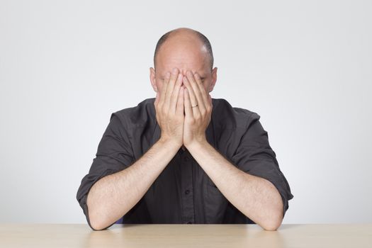 Stressed man sitting at empty desk