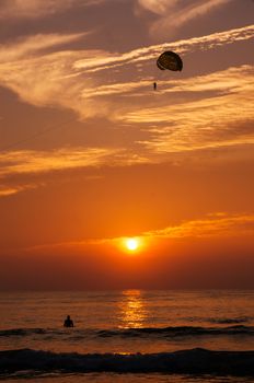 Phuket, Thailand - Oct 18, 2015 : Play para-sailing in the Patong beach on sunset. Patong beach was the most famous beach in the Phuket, Thailand. This is the famous place every tourist must come, here have many sea sport, like para-sailing, jet ski. Here also was a good sunset view point.
