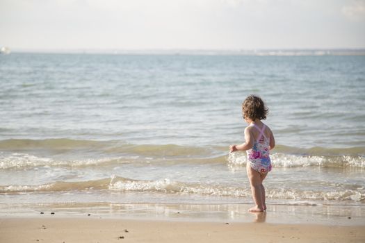 toddler considering enering the cold sea