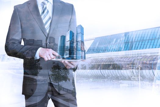 Businessman holding tablet with 3d city model on cityscape background