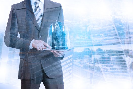 Businessman holding tablet with 3d city model on cityscape background