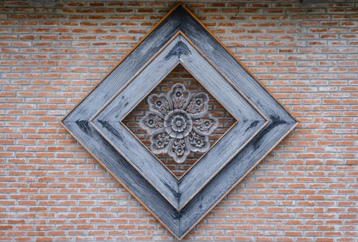 Thai style wood carving on the brick wall