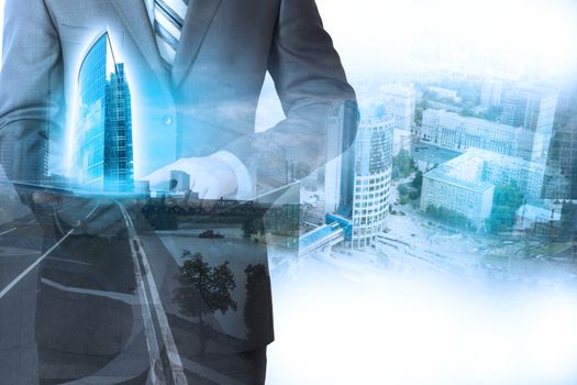 Businessman holding tablet with 3d city model on cityscape background