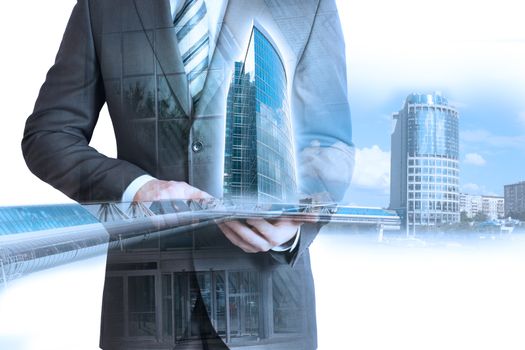 Man in suit holding tablet with 3d city model on cityscape background
