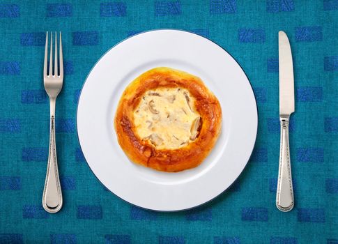 round white plate with pizza, knife and fork on table