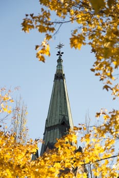 Church Steeple in Umeå, Sweden with Yellow Maple Leaves in front.