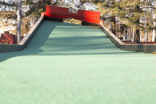 Miniature Golf Course Obstacle with pine trees behind it.