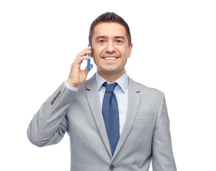 business, people and technology concept -happy businessman calling on smartphone