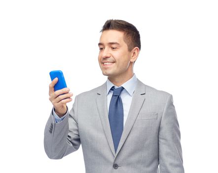 business, people and technology concept -happy businessman texting on smartphone