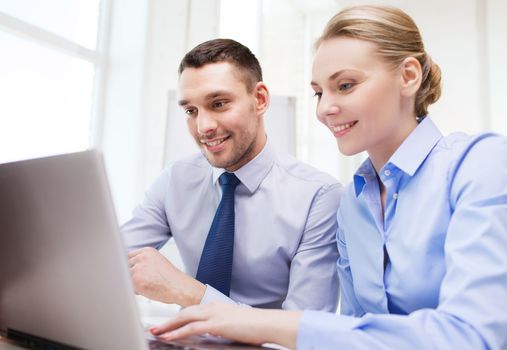 business, people, technology and teamwork concept - smiling businessman and businesswoman with laptop computer meeting in office