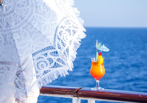 Girl with an umbrella to enjoy the journey drinking a cold cocktail